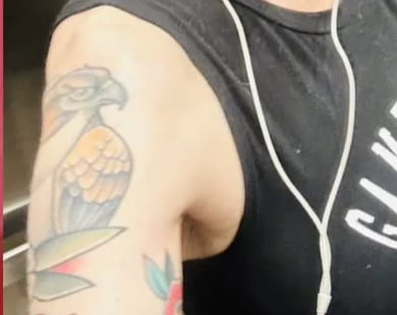 Close-up of a large American-traditional bird tattoo in orange and grey on Nancy Mace's right shoulder.