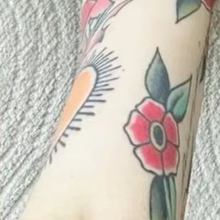 Close-up of a traditional sun or sunburst tattoo with radiating rays on Nancy Mace's right arm.