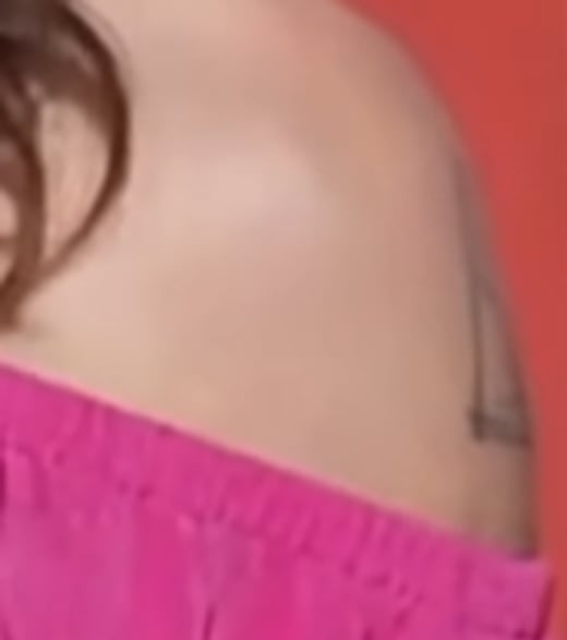 Close-up of Nancy Mace's bare left shoulder showing a strand of dark tattoo ink at the outer edge that is not clearly identifiable.